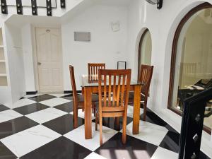 a dining room with a table and chairs on a checkered floor at Olive Periyar in Thekkady