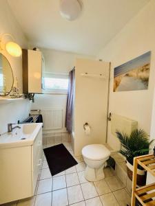 a bathroom with a toilet and a sink at Familien Ferienhaus Usedom Familie Stopp Haus 25 in Lütow