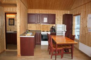 a kitchen with a wooden table and a table and chairs at Gudvangen Camping in Gudvangen