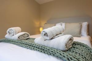 a pile of towels sitting on top of a bed at The Old Cutter Shed in Whitby +1 photo