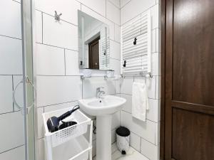 a white bathroom with a sink and a mirror at VILLA EVA - 5 min to the beach in Shekhvetili +38 photos