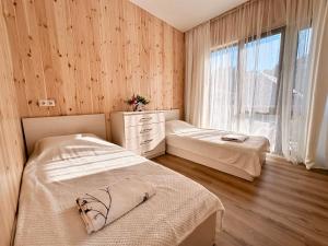 a bedroom with two beds and a window at VILLA EVA - 5 min to the beach in Shekhvetili