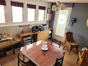 a kitchen with a wooden table and a table and chairs at Chambres d'Hôte "Du chemin vert" in Labouheyre