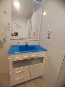 y baño con lavabo azul y espejo. en Close to the sea large 170 m2 apartmentBIKES, en Valencia