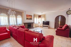 a living room with red couches and a television at Casa en Rustical in Bonmont Terres Noves