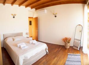 a bedroom with a bed with white sheets and a mirror at The Stone Project in Ermoupoli +36 photos