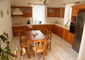 a kitchen with wooden cabinets and a table and chairs at The Stone Project in Ermoupoli