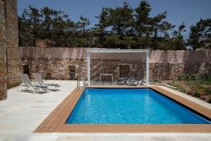 a swimming pool with a patio and a fireplace at The Stone Project in Ermoupoli
