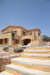 a stone house with stairs in front of it at The Stone Project in Ermoupoli