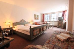 Un dormitorio con una cama, una mesa y un televisor. en Landhaus Heideschmiede, en Undeloh