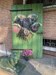 Un cuadro de una oveja en una puerta verde. en Landhaus Heideschmiede, en Undeloh