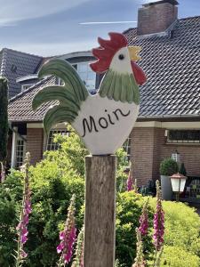 Un cartel de gallina en un poste de madera con la palabra mamá en Landhaus Heideschmiede, en Undeloh