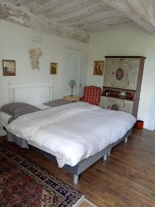 a bedroom with a large white bed and a chair at Manoir de la Chapelle in Alençon +52 photos