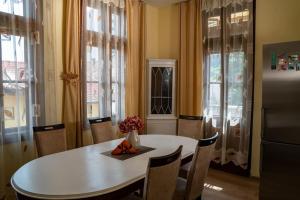 a kitchen with a white table and chairs and windows at Apartament Marrakech - City Center in Gabrovo