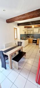 a kitchen and dining room with a wooden table at Appartement plein centre-ville in Lodève +7 photos