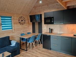 a kitchen and living room with a table and chairs at Domki Kompas in Jantar