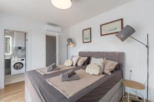 a bedroom with a large bed with white walls at Villa Sunshine by SeeAdria Agency in Karpinjan +46 photos