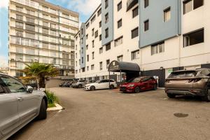 a parking lot with cars parked in front of buildings at Logis Hotel Center in Brest