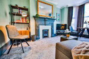 een woonkamer met een bank en een open haard bij Welcome to Nelson's Quarters in Hastings