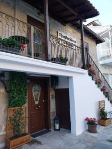 a house with a wooden door and a balcony at Πραβιτάδικο in Arnaia