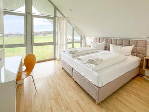 a bedroom with a large bed and a desk and window at Familienunterkunft Wiesengeflüster S3 - kinderfreundlich, nur 3 Minuten zum Strand in Röbel