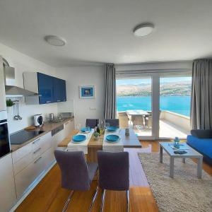 a kitchen and living room with a table and chairs at Apartments Bouvier in Pag