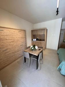 a dining room with a table and some flowers on it at Giglio di Mare Apartments in Rossano