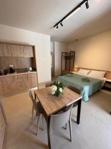 a room with a bed and a table with flowers on it at Giglio di Mare Apartments in Rossano