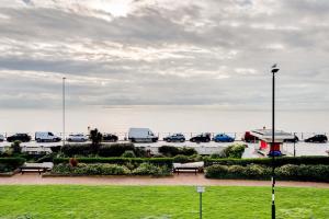 a park with cars parked in a parking lot next to the water at Beach Comber - Hastings in Hastings