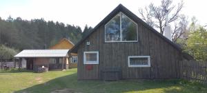 a house with a large window on the side of it at Ramintos miško namelis in Žiogeliai +9 photos