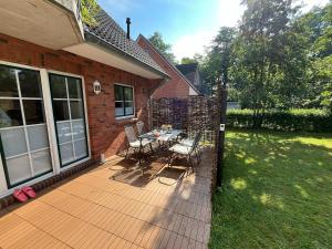 a deck with a table and chairs on a house at Kleine Robbe in Böhl