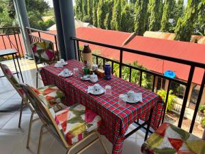 a table with cups and saucers on a balcony at Kilimanjaro Smiley Inn in Moshi
