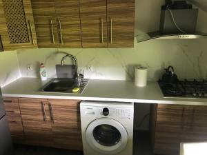 a kitchen with a sink and a washing machine at Tanie Pokoje Kajetany in Kajetany