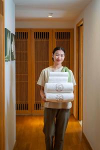 a woman is holding a stack of towels at lebua at State Tower in Bangkok