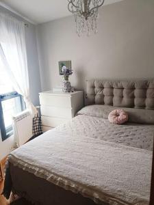 ein Schlafzimmer mit einem Bett mit einem rosa Kissen darauf in der Unterkunft Apartamento Sweet Carolinas in Vilagarcia de Arousa + 9 Fotos