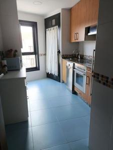 eine Küche mit weißem Fliesenboden und einem Fenster in der Unterkunft Apartamento Sweet Carolinas in Vilagarcia de Arousa