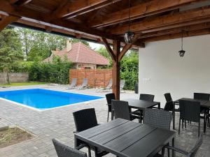 a patio with a table and chairs and a pool at Baka Apartman in Ábrahámhegy