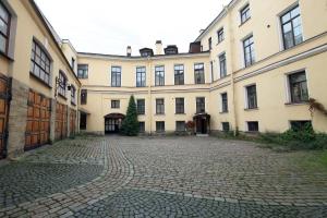 a courtyard of a large building with a cobblestone street at Hotel Park Lion Bridge in Saint Petersburg