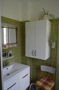a bathroom with a sink and a white cabinet at Chez Thérèse et Marguerite in Kindwiller