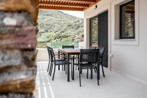 a table and chairs on the porch of a house at Alia Andros in Vitálion