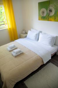 a bedroom with a large white bed with towels on it at Apartmani Maslačak in Vrdnik +119 photos