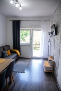 a living room with a couch and a window at Apartmani Maslačak in Vrdnik