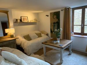 a living room with two beds and a table at Lavande in Châtelus-le-Marcheix