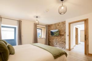 Un dormitorio con una cama y una pared de piedra. en Canny Grouse Barn, en Kirkby Stephen 49 fotos más