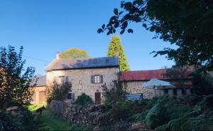 a large stone house with a roof on a hill at Lavande in Châtelus-le-Marcheix