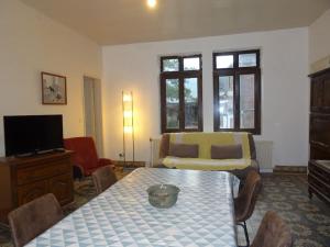 a living room with a table and a tv at maison de famille in Driencourt