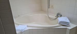a bathroom with a bath tub with two blue towels at Ferienwohnung mit Dachterrasse in Eicklingen