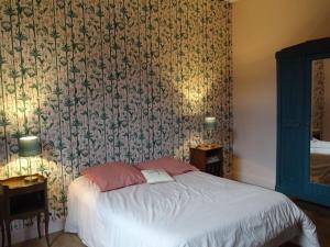 a bedroom with a bed with a floral wallpaper at maison de famille in Driencourt