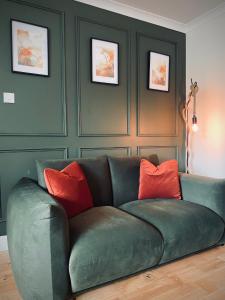ein grünes Sofa mit roten Kissen in einem Zimmer in der Unterkunft Lochside Guest House in Arrochar