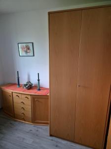 a room with a wooden cabinet and a desk at Ferienwohnung Feldblick in Isernhagen